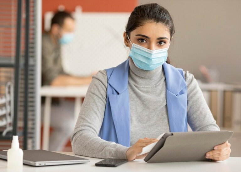 employee-disinfecting-electronic-device_23-2148727592