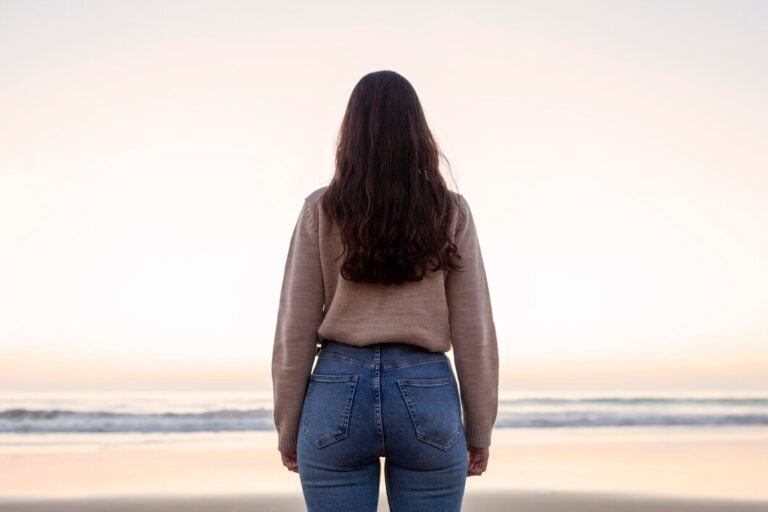 back-view-woman-posing-by-beach_23-2148648008
